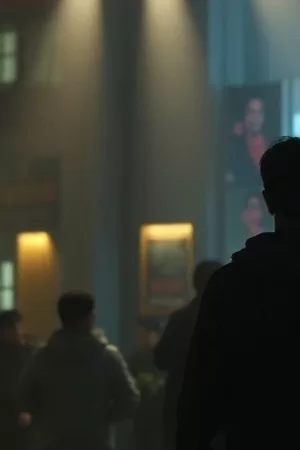 旧胶片盒与放映厅座椅的竖版主视觉，暖黄灯光下的木质地板
